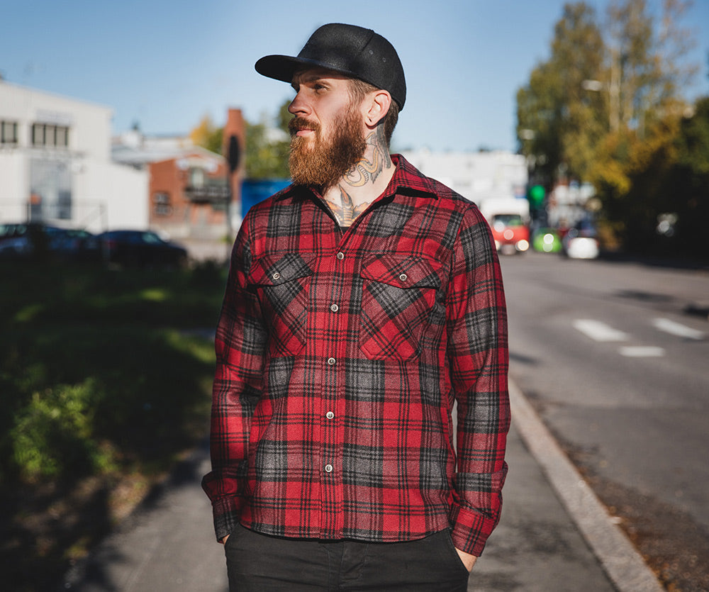 The model's true size would be Large; but he likes a bit more form fitting clothes; so he picked size Medium. With a woolen garment this works; as the material stretches and forms a bit.