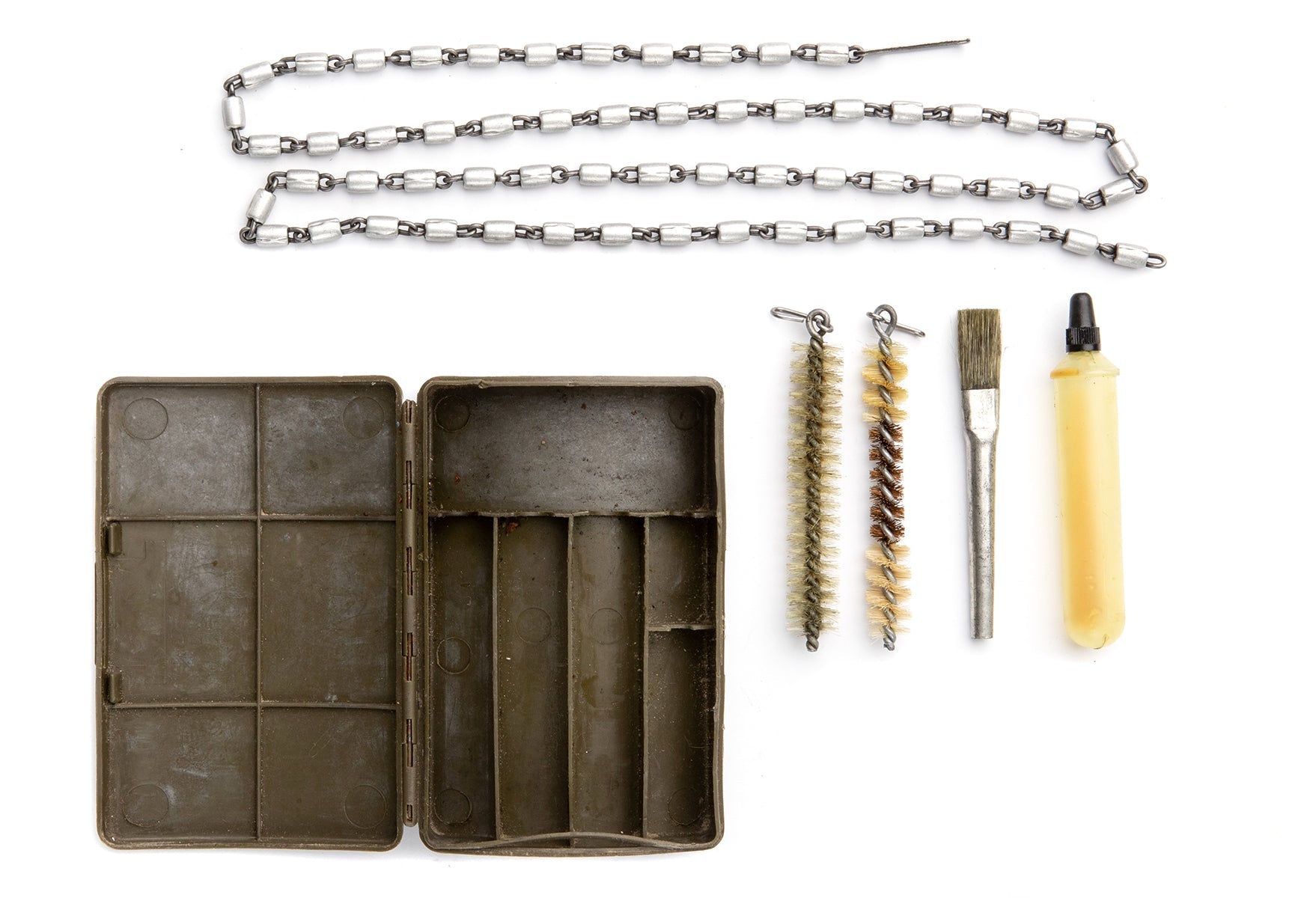 The equipment comes in a plastic box that reveals two brushes that are clipped on the bore chain; a soft brush for spreading oil as well as a bottle for storing that oil.