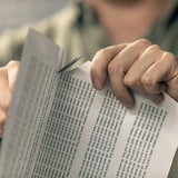 Man holding a paper full of "All work and no play makes Jack a dull boy" quotes, and cuts the paper with Varusteleka Jääkäripuukko 110
