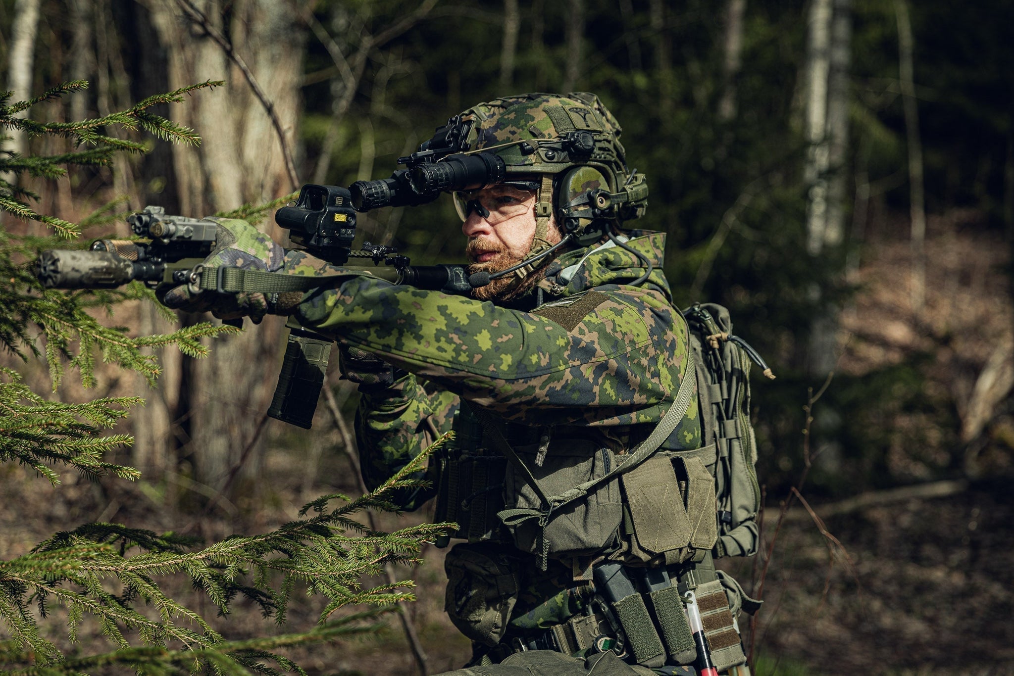 Man in the forest holding an AR 15 and dressed in Varusteleka gear, including the L3 Softshell