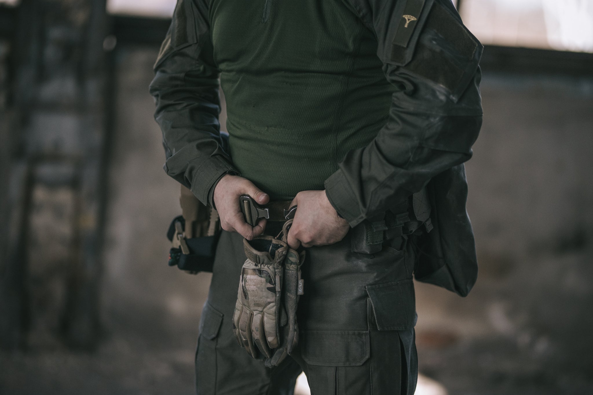 Person in tactical gear closing his belt with a blurred background