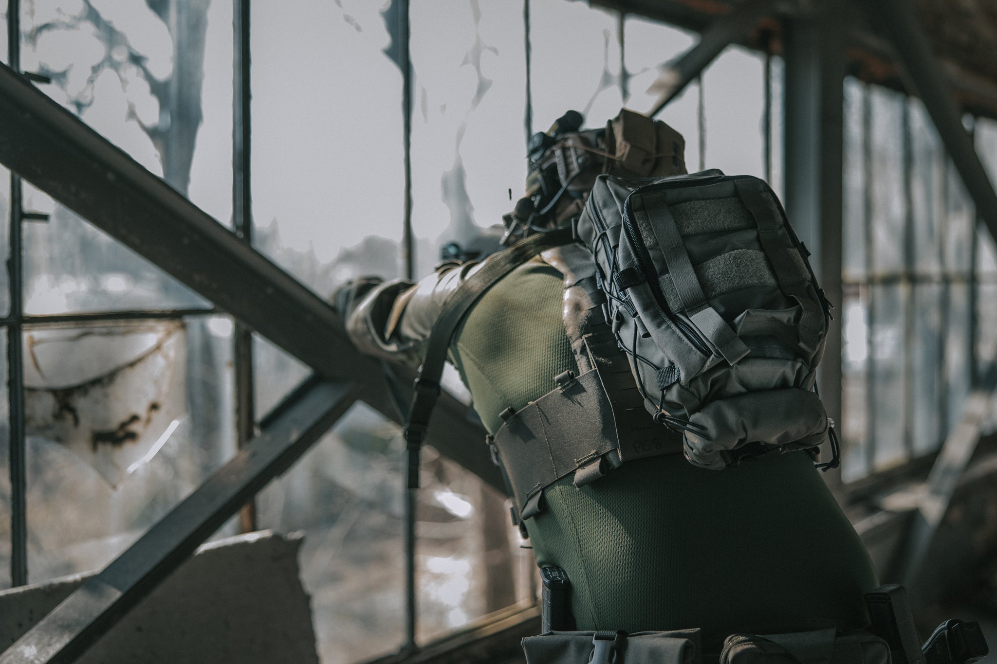 Person in tactical gear with a backpack in an industrial setting