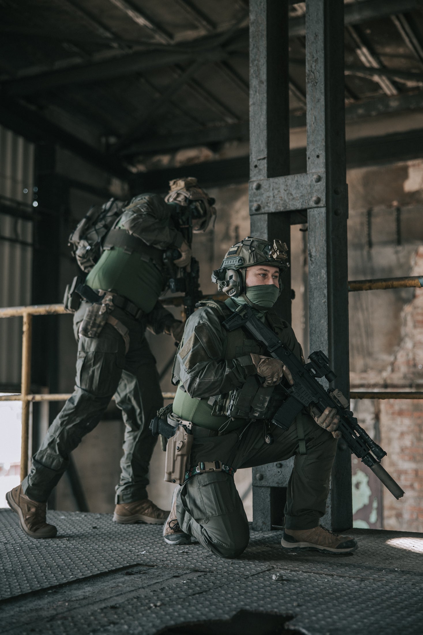 Two soldiers in tactical gear in an industrial setting