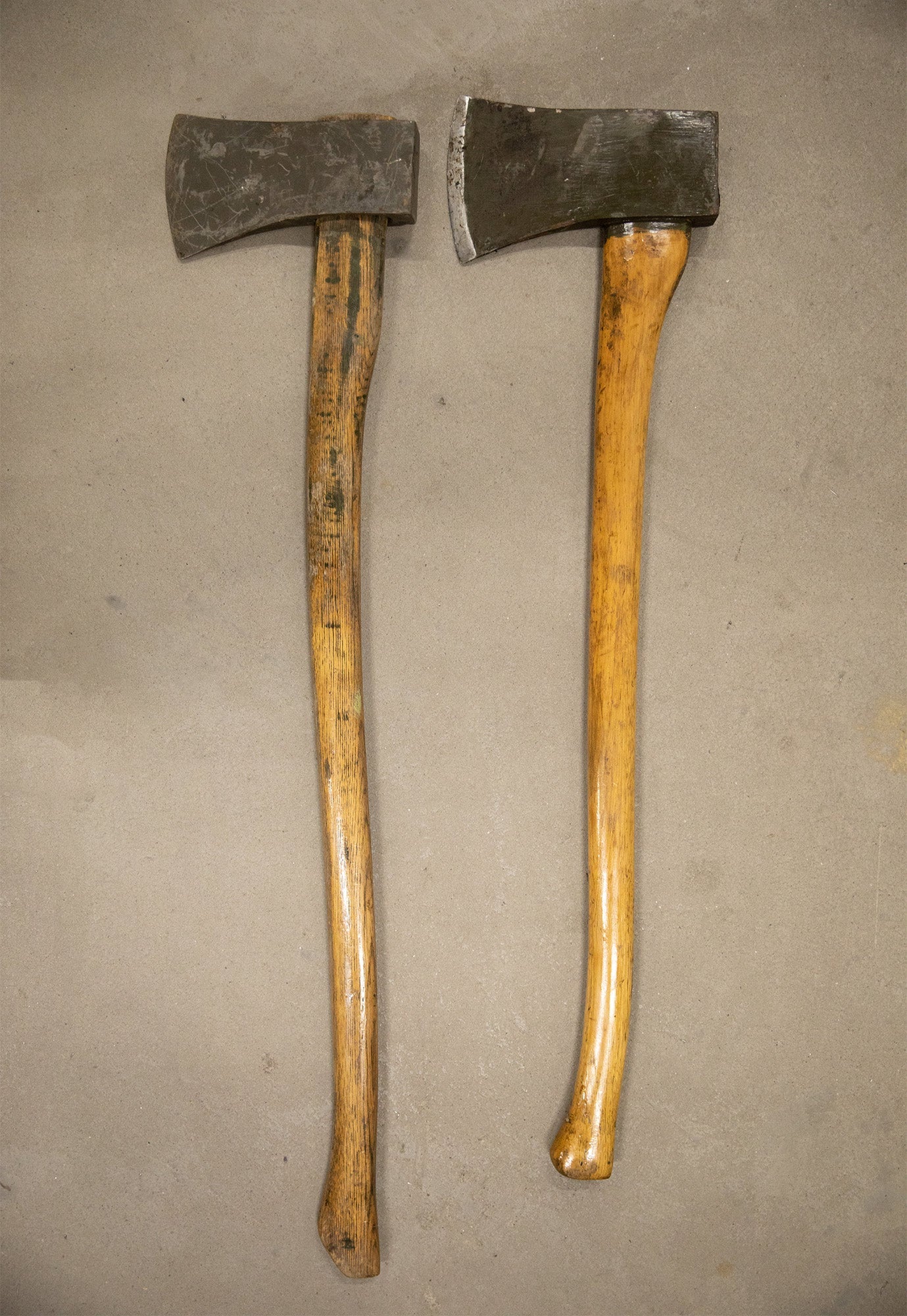 Two wooden handled Dutch military axes side by side.
