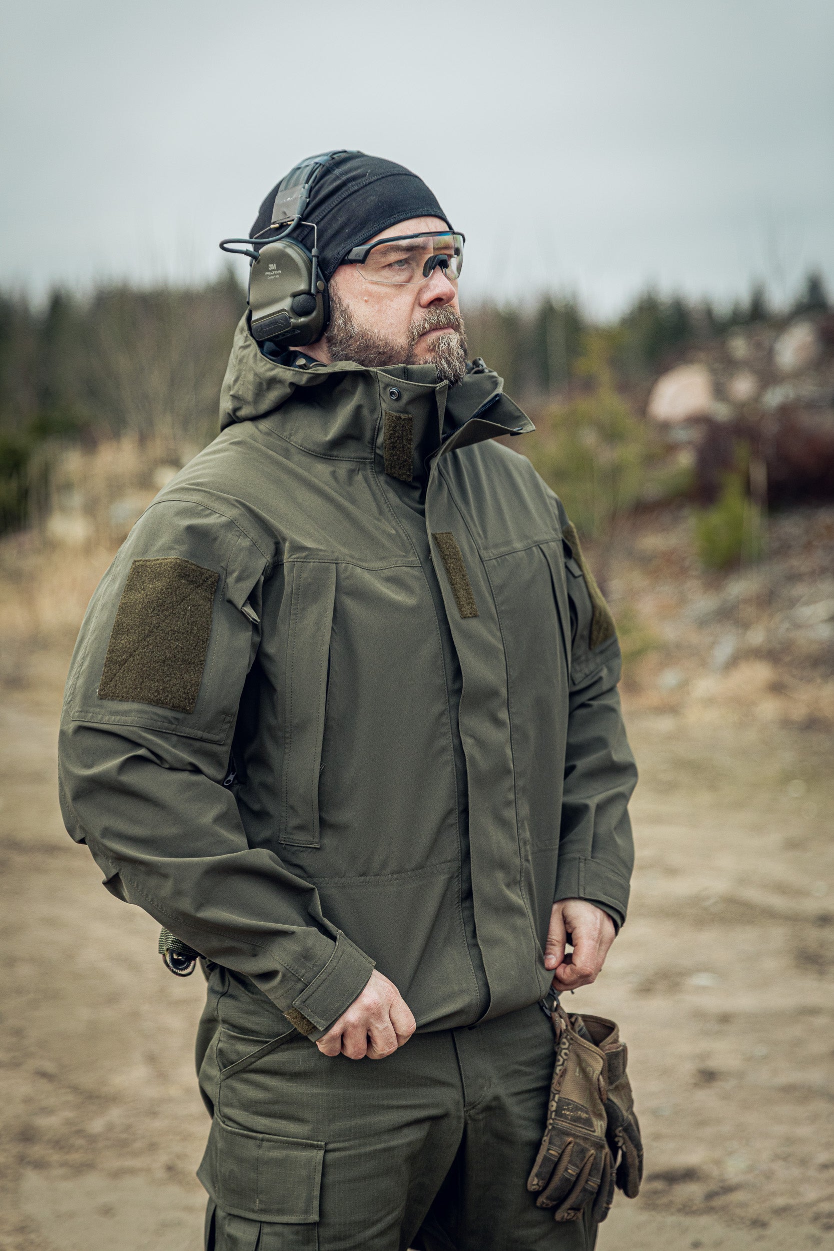 Man in tactical gear standing in a natural outdoor setting