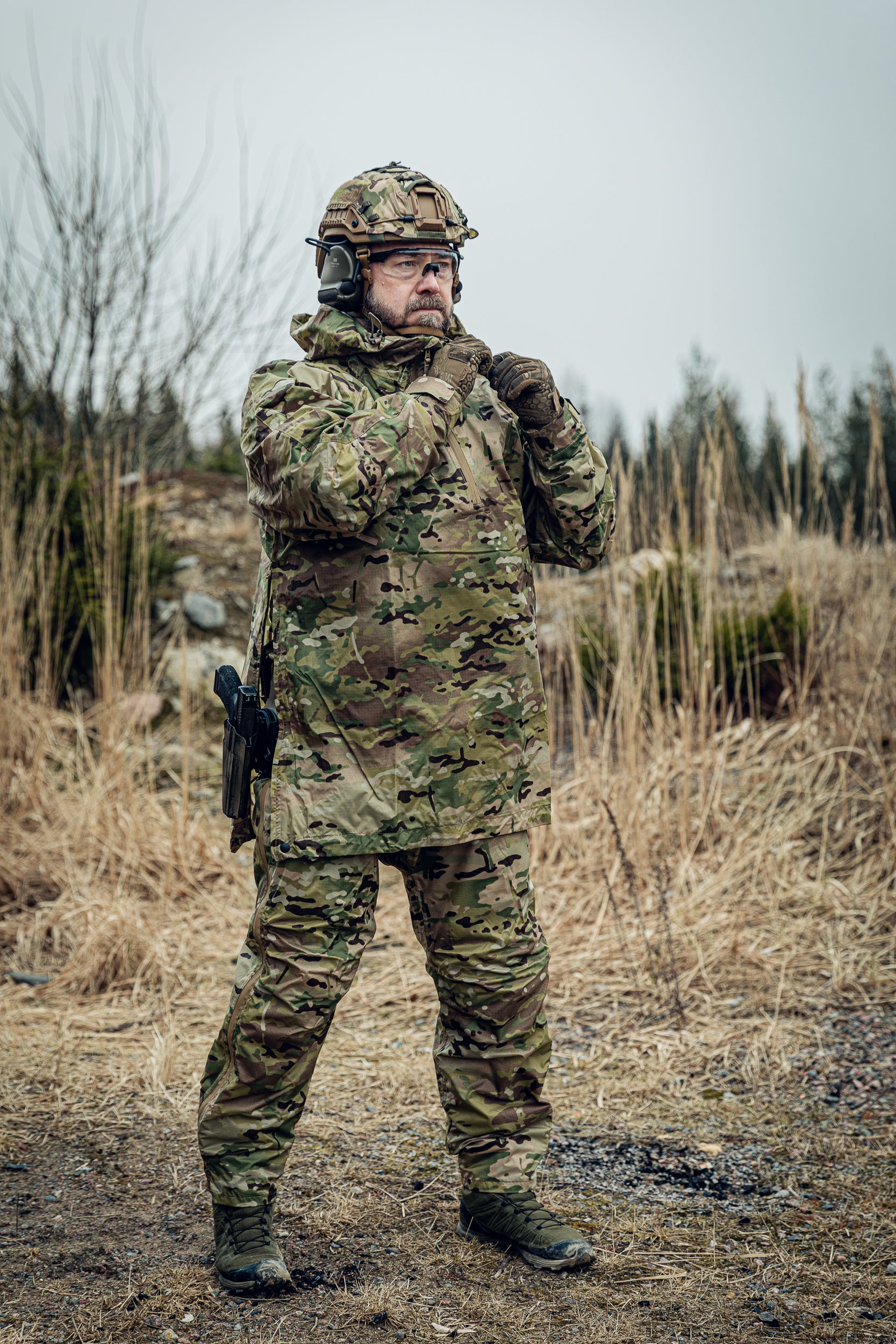 Person in camouflage military uniform standing in a natural setting
