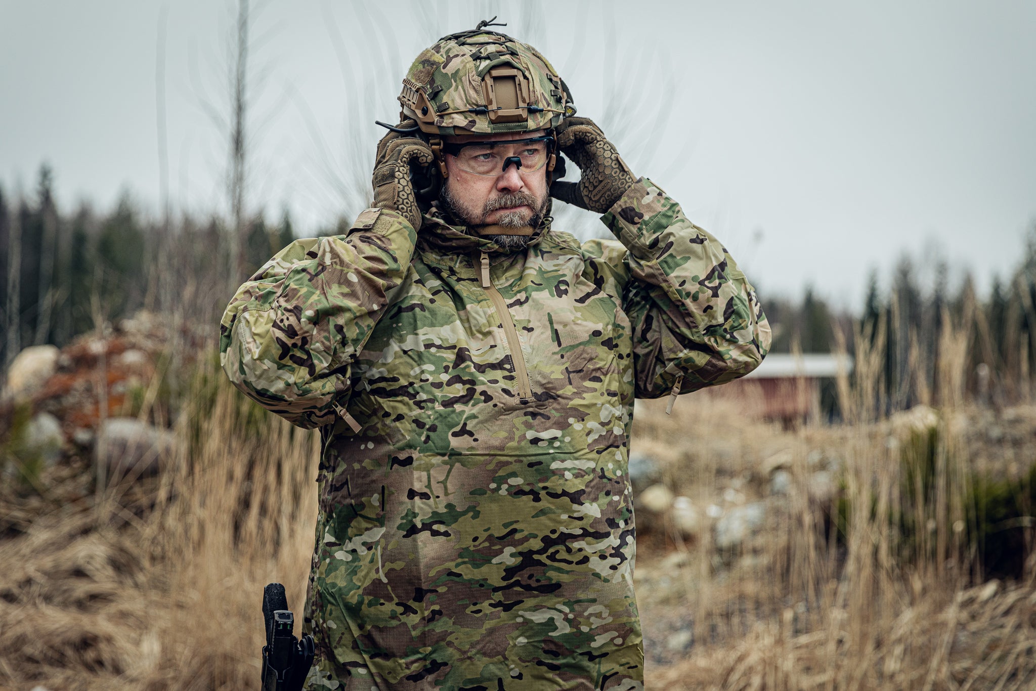 Person in military camouflage gear in a natural setting