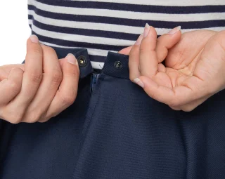 Zips up in the back with a snap-fastener on top.