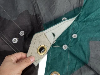 Sewn-on buttons and strong grommets. Pictured here is an unused example.