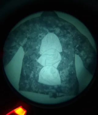 IR illuminated. Underneath the hats a NIR-compliant M05 RES jacket with a M05 Woodland camouflage.